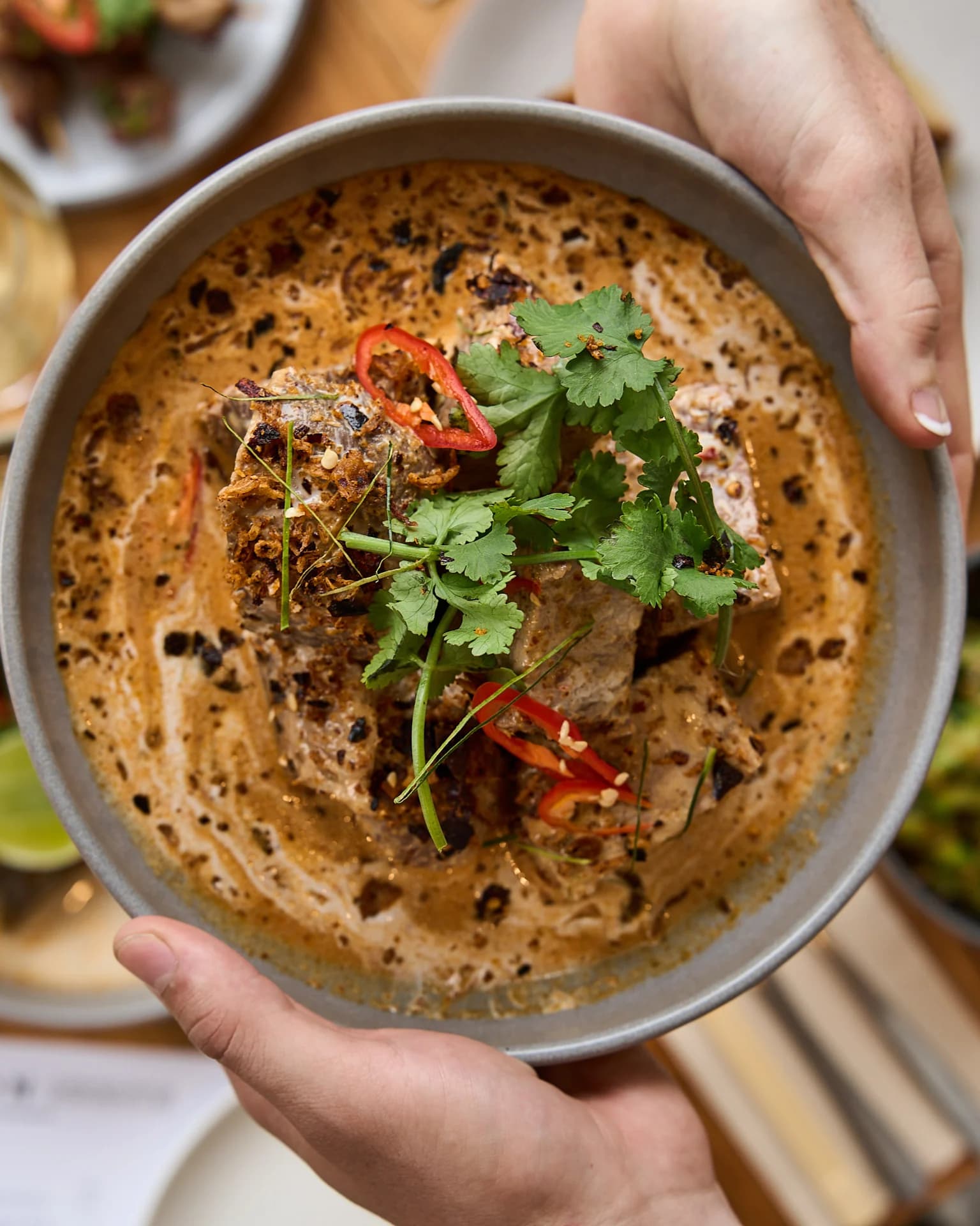 Close-up of a bowl topped with herbs and chilli